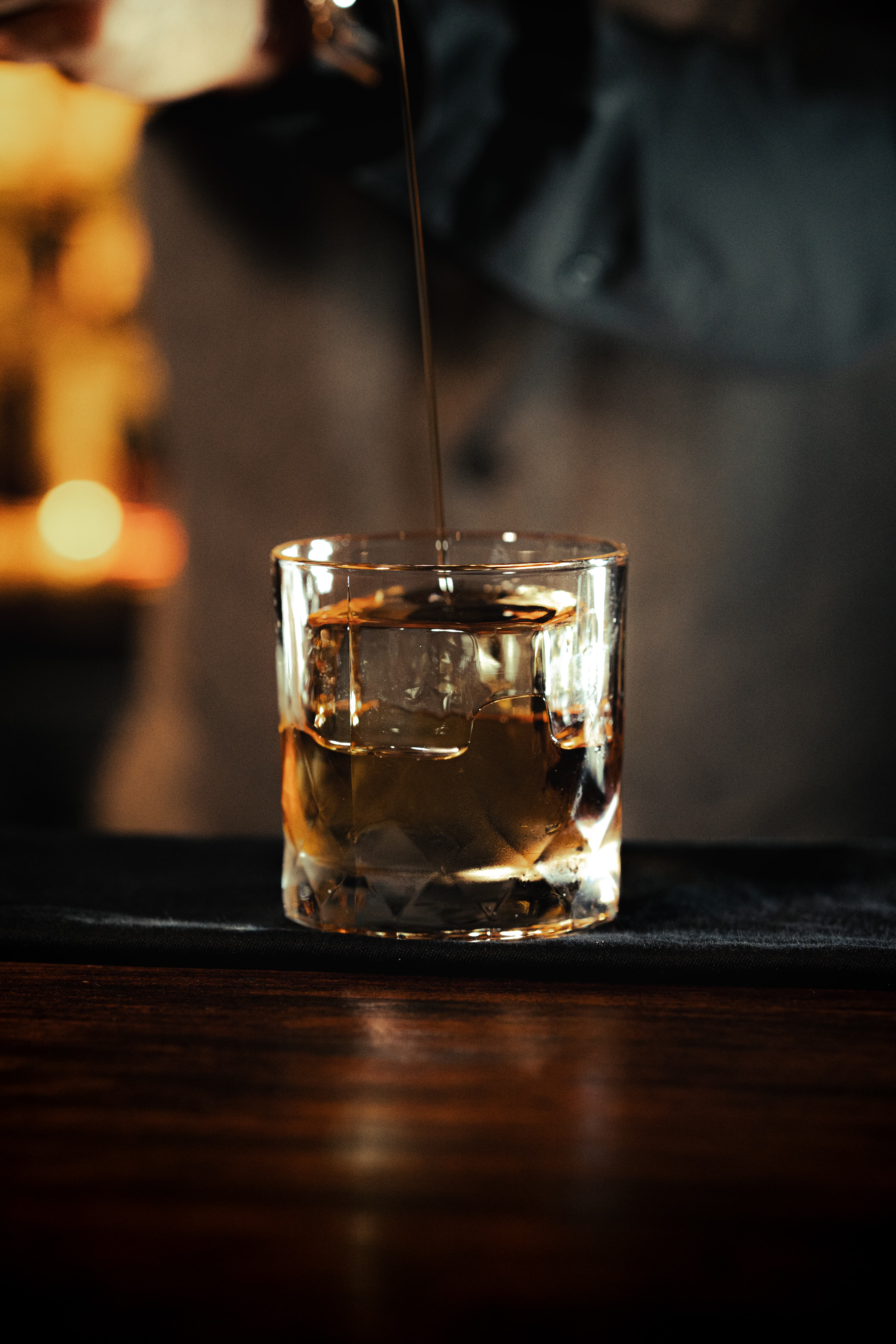 Whiskey being poured over a KORI ice cube